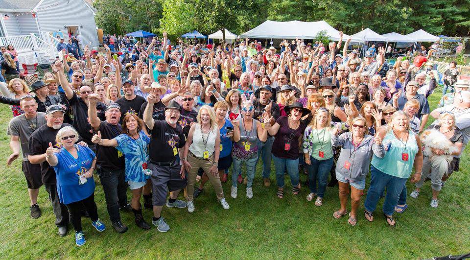 A large group of people standing in the grass.